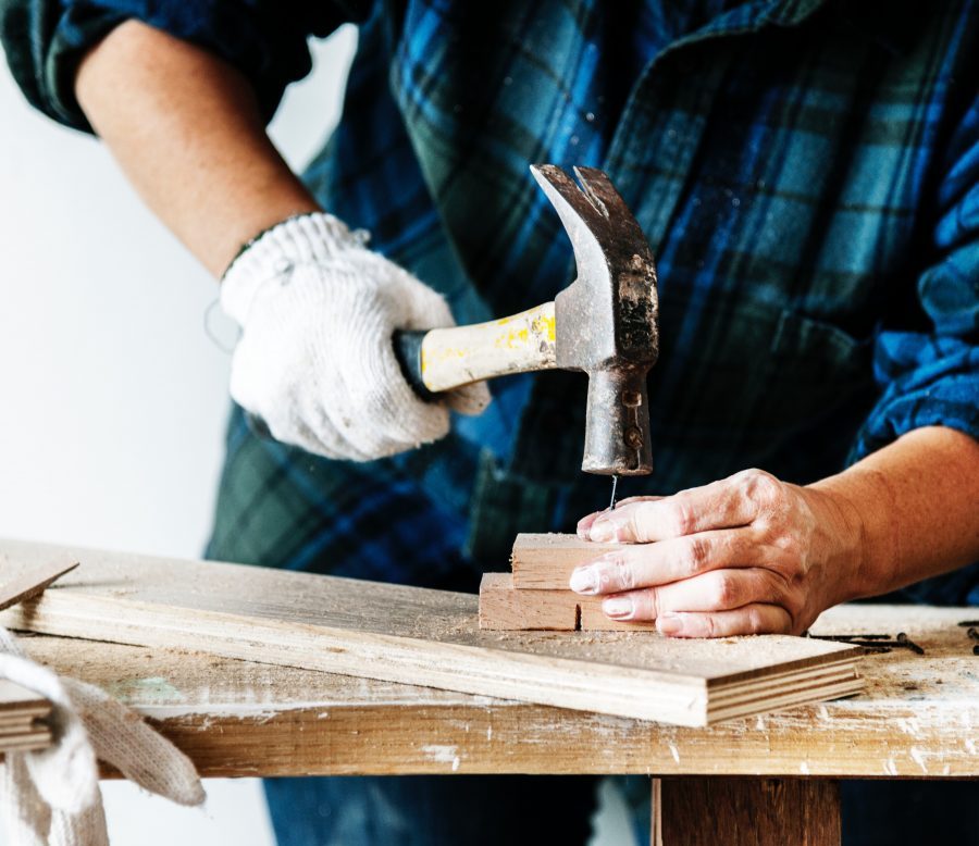 person hammering hail into wood